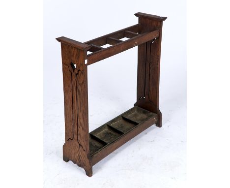 AN OAK ARTS &amp; CRAFTS STICK STAND, C1900, THE PIERCED ENDS WITH SINUOUS TRAIL AND HEART MOTIFS, FOUR APERTURES, PAINTED TI
