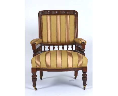 A LATE VICTORIAN MAHOGANY ARMCHAIR, THE TOP RAIL FLUTED AND CARVED FIVE ROSETTES, UPHOLSTERED BACK, ARM PADS AND BOWED SEAT I