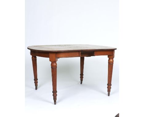 A VICTORIAN OAK EXTENDING DINING TABLE, C1870, THE SHAPED RECTANGULAR TOP WITH REEDED LIP ABOVE SHALLOW FRIEZE AND FLUTED TUR