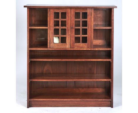 AN ARTS AND CRAFTS WALNUT BOOKCASE, C1900, THE OVERSAILING RECTANGULAR TOP ABOVE A PAIR OF GLAZED DOORS REVEALING ADJUSTABLE 