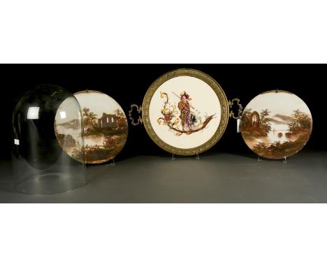 A VICTORIAN CIRCULAR BRASS MOUNTED POTTERY TWO HANDLED TRAY, THE CENTRE DECORATED WITH A CONTINENTAL SWORDSMAN HOLDING A SHIE