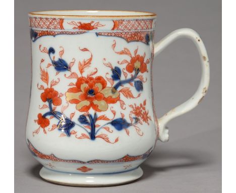 A CHINESE IMARI MUG, C1770, OF BALUSTER FORM, DECORATED WITH PEONY IN TWO PANELS RESERVED ON A GROUND OF LOTUS BENEATH PANELL