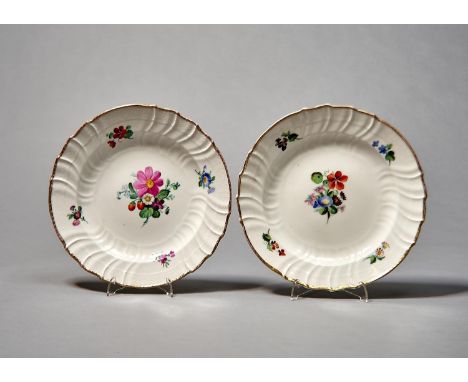 A PAIR OF BERLIN PLATES, C1850-70, PAINTED WITH A LOOSE BOUQUET AND FOUR SINGLE FLOWERS IN OSIER MOULDED BORDER AND GILT RIM,