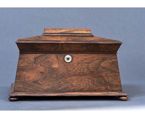 A POST REGENCY ROSEWOOD VENEERED SARCOPHAGUS SHAPED TEA CADDY, C1830, THE TOP WITH DOMED PANEL, THE SPLAYED FRONT WITH MOTHER