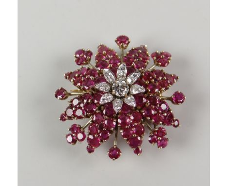 AN 18CT YELLOW & WHITE GOLD DIAMOND & RUBY STAR BURST BROOCH the central diamond surrounded by eight petals, raised on a bed 