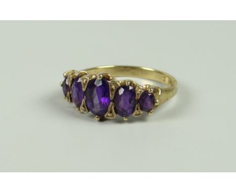 A YELLOW GOLD (MARKS UNCLEAR) FIVE GRADUATED AMETHYST RING, 3.2grams approx, (size N/O)