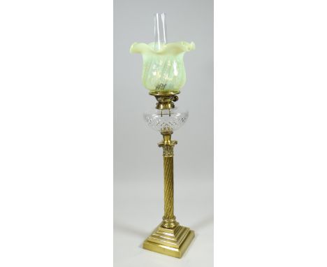 AN ANTIQUE BRASS OIL LAMP with twist-style column on a stepped base, cut-glass reservoir & vaseline glass shade, 87cms high