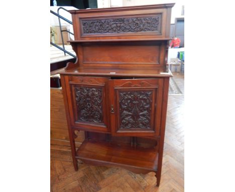 A late Victorian walnut side cabinet, the back with open shelf and carved foliate panel, a pair of foliate carved panel doors