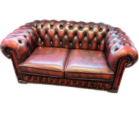 Chesterfield two seat settee, covered in a red leather button upholstery