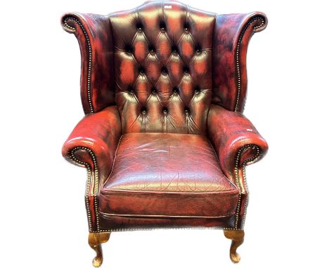 Chesterfield Gullwing chair, covered in a red leather button upholstery 