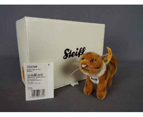 Steiff - a Steiff Radjah Tiger #033346 with yellow label, button in ear and tag under chin, Approx 10 cm x 16 cm, comes with 