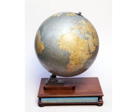 A Globe Indemnity Company Silver Anniversary globe on stand with Rand McNally Ready-Reference Atlas of the World below. H42cm