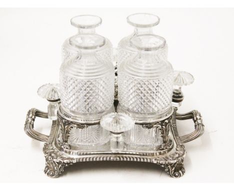 A George IV silver four bottle decanter stand with gadrooned edge, fluted handles on four shell and scroll feet, Paul Storr, 