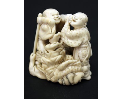 A Japanese carved ivory figure or netsuke depicting three men and two women in an entangled fight, signature to base, height 