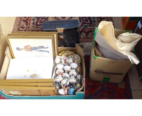 A box containing ceramic handles, military prints, a collection of books, and a monitor 