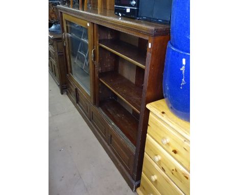 A large late Victorian mahogany bookcase, with 2 sliding glazed doors, adjustable shelves and panelled cupboards under, on pl