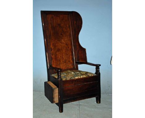 An 18th century Fruitwood and Oak Lambing or Shepherds Chair, panelled back with shaped wing sides, S shape arms with round t