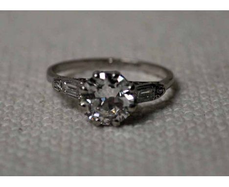 A platinum and diamond Solitaire Ring, eight claw set brilliant approx. 1.2ct flanked to each shoulder by rectangular baguett