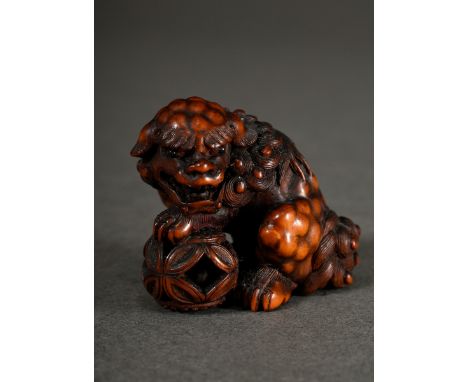 Sehr fein geschnitztes Buchsbaum Netsuke "Shishi mit drei beweglichen Kugeln im Korb", mit in dunklem Glas eingelegten Augen,