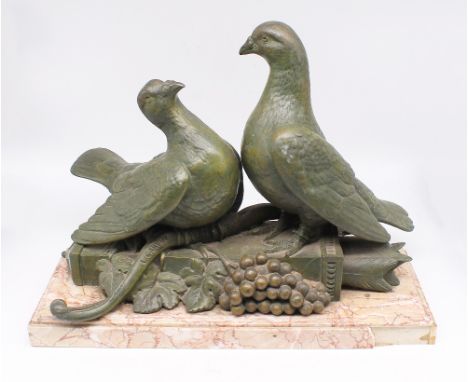 After L. Carvin - a 20th century patinated spelter figure of two pigeons sitting on a bow and quiver with arrows and fruiting