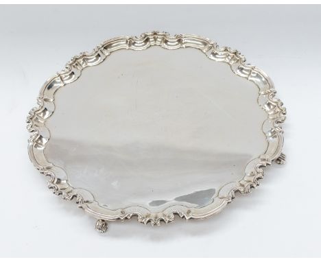 A George V large silver salver, pie crust border on four scroll feet, hallmarked by William Hutton &amp; Sons., Sheffield, 19