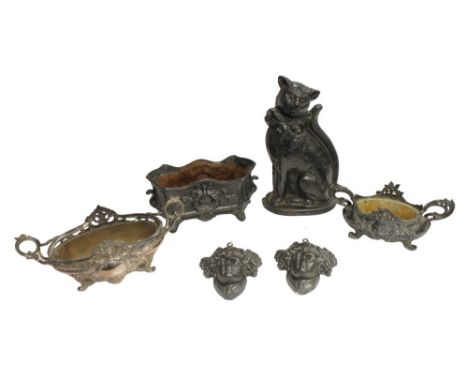 A cast-iron cat doorstop, an elaborately designed 19th century iron planter, two Art Nouveau style cast iron figural face pla