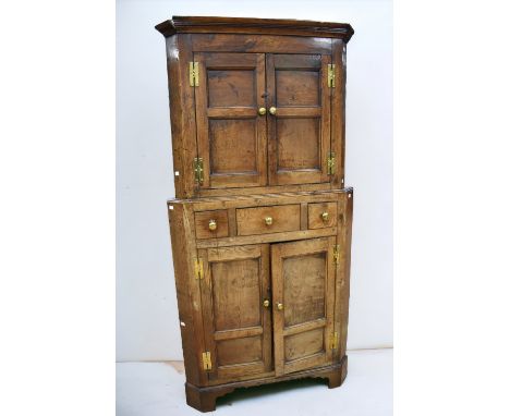 George III floor standing solid English oak corner cupboard in two parts:- top has two opening cupboard doors to reveal shelv