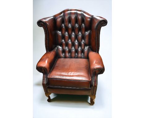 Two 20th century ox-blood button back Chesterfield style fireside wingback armchairs. Condition: Good condition, a few rubs.
