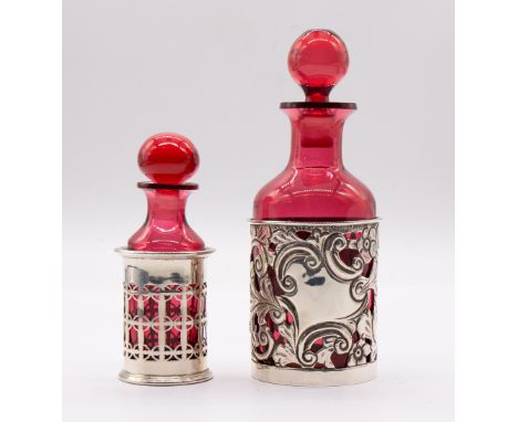 An Edwardian ruby glass scent bottle and stopper held in silver holder pierced and engraved with flowers and foliage, hallmar