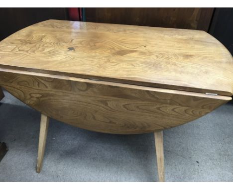 A Ercol drop leaf table with four matching open arm chairs.