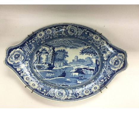 A Victorian blue and white transfer printed dish depicting figures by a lake with sheep and cattle, approx width 42cm. Shippi
