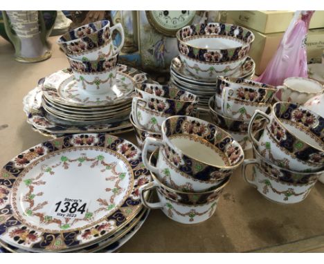 A British porcelain tea set early 20th century with a gilt and deep blue pattern eight cups saucers sugar bowl and side plate