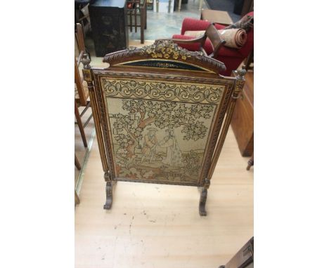 A Victorian firescreen, silk back panel, the front with cross-stitch and tapestry scene depicting two figures in a garden set