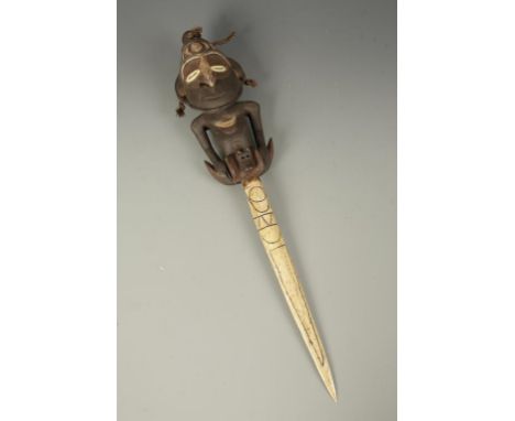PAPUA NEW GUINEA: A CEREMONIAL KNIFE with carved pointed bone blade, the handle in human form with painted eyes and details, 