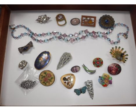 A COLLECTION OF VINTAGE COSTUME JEWELLERY including enamel brooches and a blue and mauve coloured glass beaded necklace