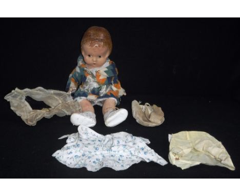 A VINTAGE 1930S  COMPOSITE DOLL of a young girl with a period hairstyle, dressed in original multi-coloured 'Jazz' style felt