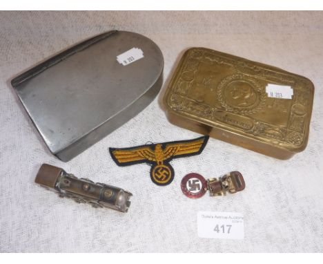 A WORLD WAR I PRINCESS MARY TIN containing a Trench Art lighter in the form of a brass locomotive, a 'Nazi' cloth badge, a sw