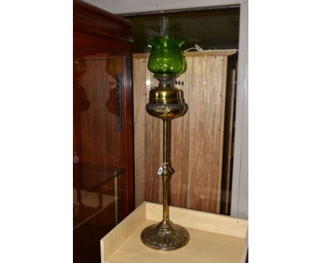 A LATE 19TH/EARLY 20TH CENTURY BRASS OIL LAMP, having brass reservoir, glass funnel and green glass shade, total height appro