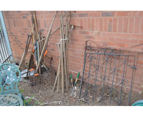 A QUANTITY OF VINTAGE GARDEN AND FARMING TOOLS including scythe, hay fork, shears, edge clippers and two wrought iron gates e