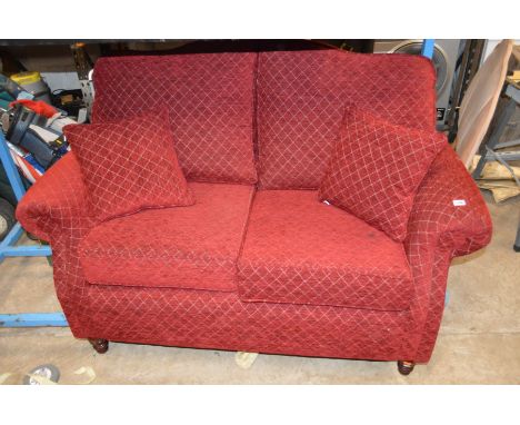 A DEEP RED UPHOLSTERED TWO SEATER SOFA, width 150cm