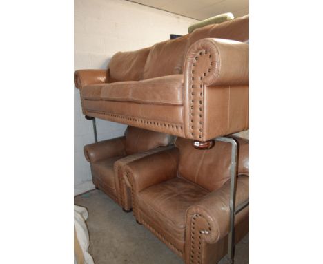 A FAWN LEATHER THREE PIECE LOUNGE SUITE consisting of a three seater sofa, width 227cm and two single chairs, width 112cm