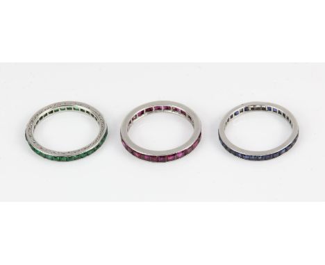 Three gem set full eternity rings, each set with square cut gemstones, one ring set with sapphires, one with rubies, and one 