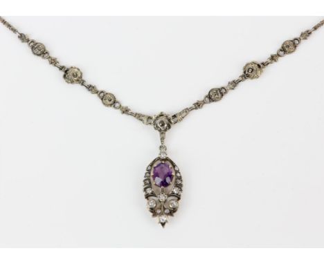 An amethyst and diamond pendant, centrally set with an oval cut amethyst, with a surround of old cut diamonds in a foliate de