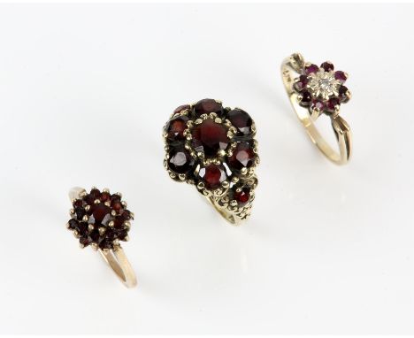 Three cluster rings, including a ruby and diamond cluster ring, size K, a red paste cluster ring, size N½, and another red pa