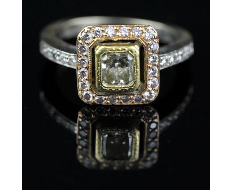 Modern diamond cluster ring, with a central radiant cut light yellow diamond weighing an estimated 0.70 carat, surrounded by 