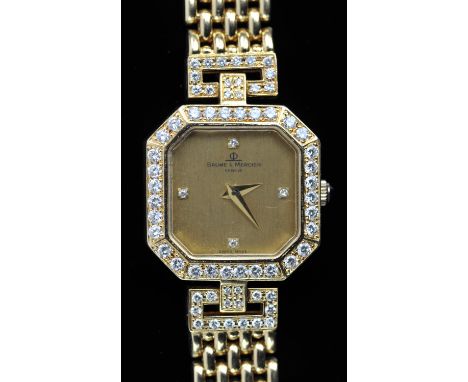 A Baume and Mercier Ladies Gold and diamond set watch, The diamond set bezel surmounting a signed dial with diamond hour mark