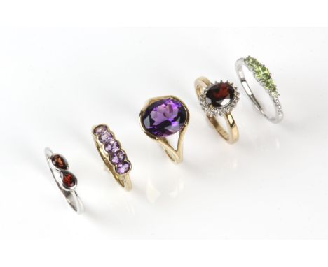 Five 9 ct gem set rings, including a amethyst single stone ring, size K, a five stone amethyst ring, size L, a garnet cluster