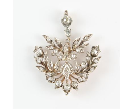 A diamond set openwork drop pendant, foliate spray design set with rose and old cut diamonds, mounted in silver and 9 ct, wit