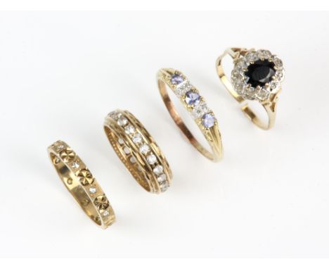 Four gem set rings including a sapphire and diamond cluster ring in 9 ct with a cut shank, a tanzanite and diamond ring in 9 