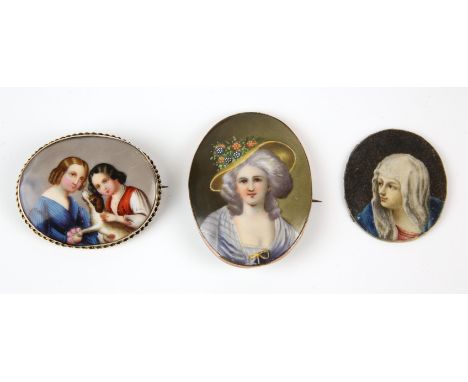 Two gold plated painted portrait brooches, one of Elisabeth De France, the other depicting two women and a dog, together with